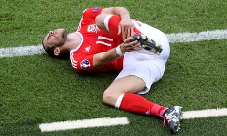 Wales’ Gareth Bale holds his foot after a tackle by Northern Ireland’s Stuart Dallas.