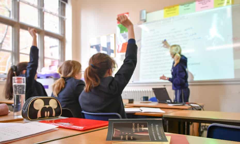 Classroom with children raising their hands
