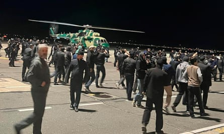 أشخاص على مدرج مطار محج قلعة في داغستان حيث كان مثيرو الشغب يبحثون عن ركاب يهود قادمين من إسرائيل