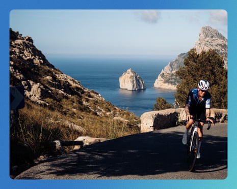 Paddy Maddison cycles uphill on a coastal mountain road overlooking the sea