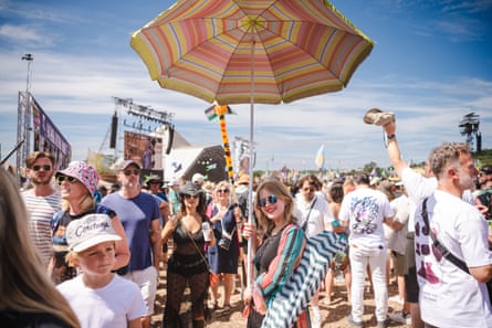 An umbrella provides one festivalgoer with shade in the often intense heat.