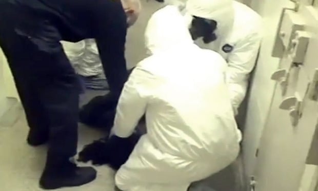 In this 3 February 2015 frame from video provided by the Fairfax County sheriff, deputies work to restrain Natasha McKenna during a cell transfer.