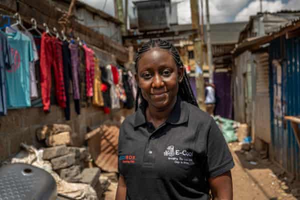 Norah Magero poses in an alleyway among breeze block buildings