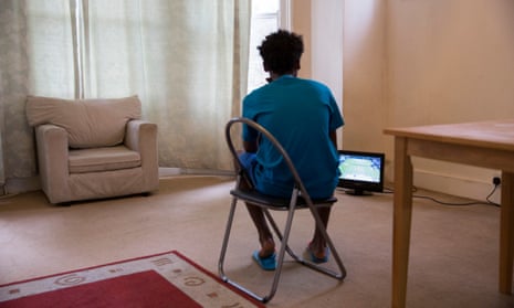 An unaccompanied minor refugee child sits watching a television that has just been donated by a friend in his front room where he has been recently housed. 
