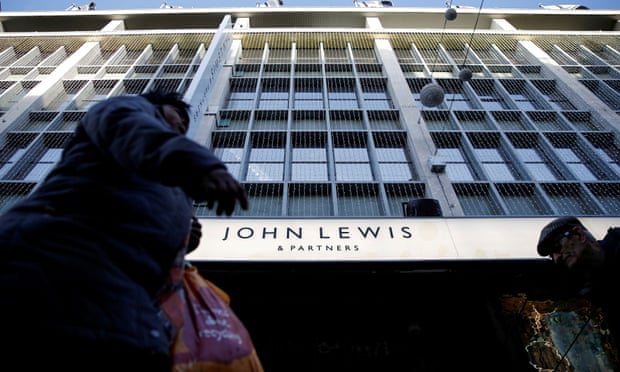Shoppers walk past the John Lewis department store on Oxford Street.