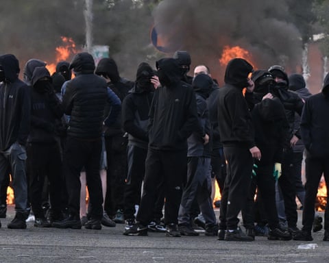 A gang of youths in Belfast, dressed in black with covered faces