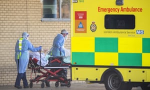 NHS workers take a patient from an ambulance at Queens Hospital in April