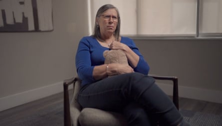 A middle-aged woman sits in a chair