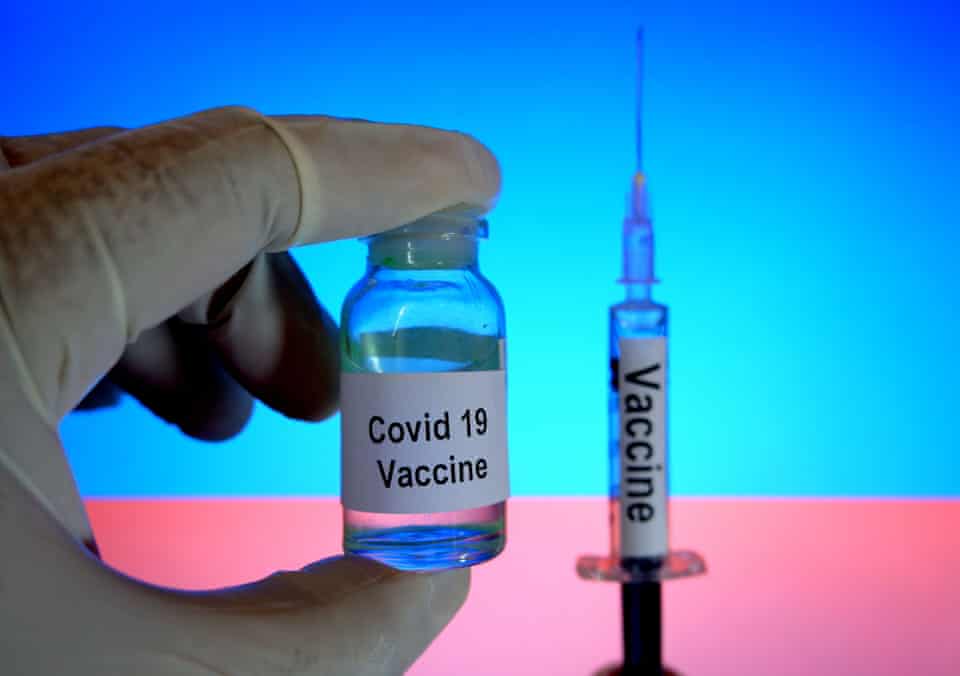 A phial with ‘Covid-19 Vaccine’ written on it and a syringe 