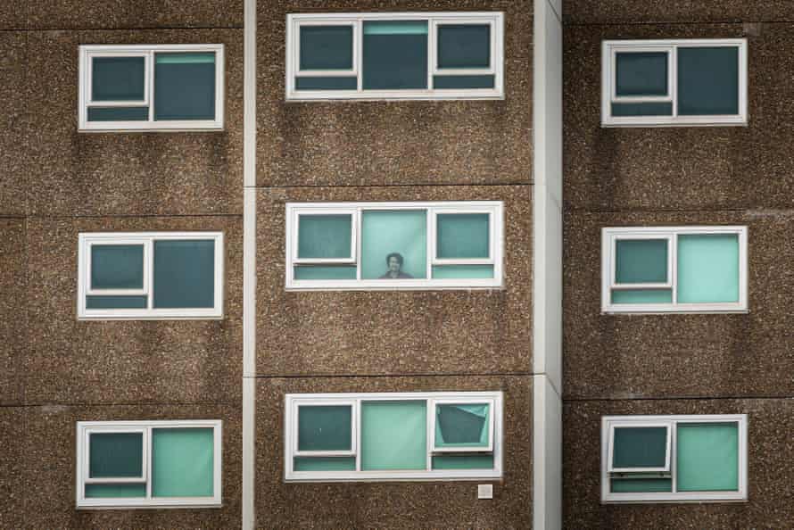A lone woman is seen looking out the window of her apartment at the North Melbourne Public housing flats on July 05, 2020 in Melbourne, Australia.
