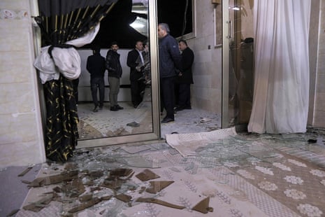 People inspect damage at a building