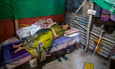 Manju Bibi, a domestic servant, rests in her room in a New Delhi slum, India.