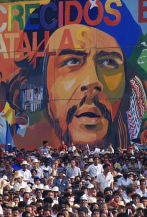 A crowd gathers in front of a mural of Che Guevara during celebrations marking the 35th anniversary of the Cuban revolution, 1989
