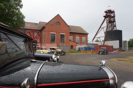 Classic cars are parked in front of the former mine buildings and apparatus.