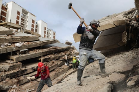Rescuers work atop the rubble of a collapsed building in La Guaira following the twin earthquakes in Venezuela last month
