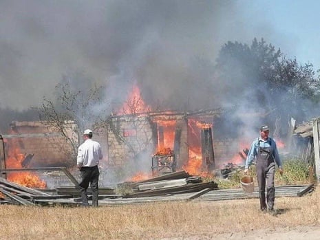 Local residents walk next to damaged buildings after a Russian strike in Kyiv region.