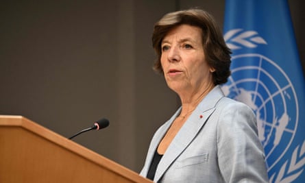 Catherine Colonna, the French foreign minister, speaking behind wooden lectern in front of the UN flag