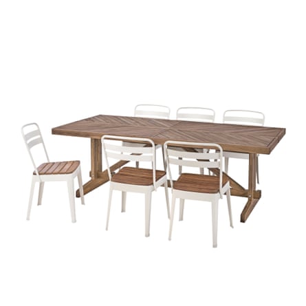 A dark wooden table with a middle support surrounded by 6 white metal chairs with wooden seats.