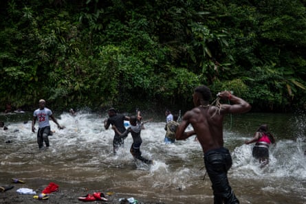 A group of people in a river playing, some with rope in their hands