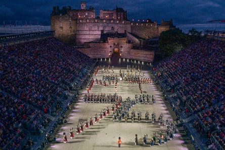 The Massed Pipes and Drums inn formation during the 75th Royal Edinburgh Military Tattoo outside Edinburgh Castle, lit up at night