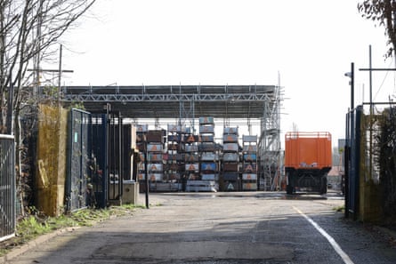 A building yard at the site with a truck parked to the side of a unit with open sides.
