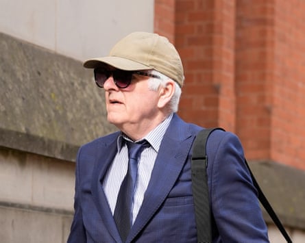 Graham Brougham wearing a suit and tie, baseball cap and sunglasses