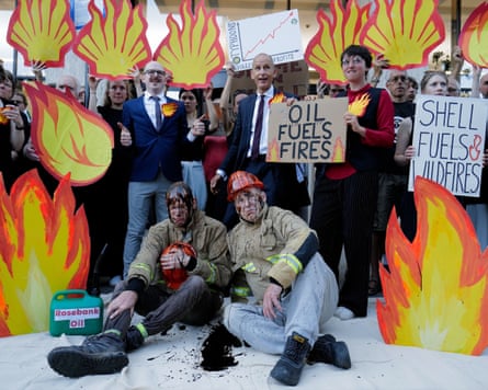 Activists and campaigners holding placards that read ‘Oil fuels fires’ and ‘Shell fuels fires and wildfires’.