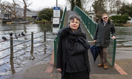 Eel Pie Island resident and activist Celia Holman standing on the Twickenham side of the footbridge over the Thames at high tide.