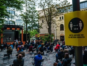 A sign reads ‘Please keep a distance of 1.5 meters’ during the presentation of ‘Die Blechtrommel’ (The Tin Drum) on an open-air stage in front of socially distanced spectators in the yard of the Berliner Ensemble theatre in Berlin, Germany.