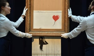 Sothebyâs employees with Banksyâs shredded Girl with Balloon.