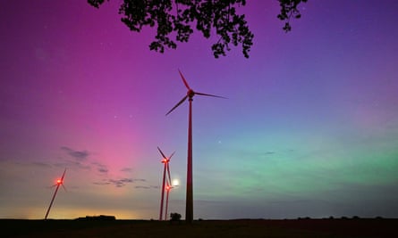 Wind turbines backlit by the aurora near Sieversdorf in Germany