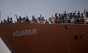 Migrants wave from the Aquarius during an earlier rescue operation. 4000.jpg?w=300&q=55&auto=format&usm=12&f