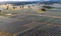 Aerial view of a solar panel farm in rural area at sunrise
