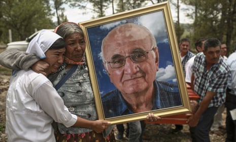 Women hold a portrait of Jesuit priest Javier Campos Morales as his funeral procession and that of fellow priest Joaquín César Mora Salazar arrives to Cerocahui, Chihuahua state, Mexico, on 26 June.