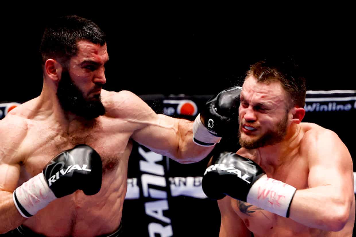 Артур Бетербиев (слева) наносит удар левой рукой по боксеру из Германии Адаму Дайнесу во время их титульного боя в марте 2021 года в Москве. Фотография: Anadolu Agency/Getty Images