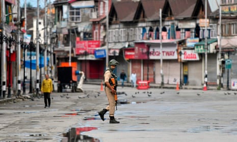 A member of the Indian security forces patrols a deserted road in Srinagar