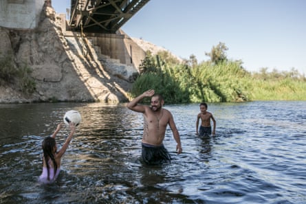 David Barraga plays ball with his daughter Dariana and his step-son Damien in the Colorado River in Gateway Park, Yuma, Arizona on 7 September 2019.