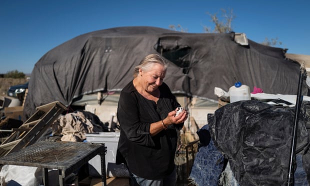 Mojave Desert, CA July 06: Aletha Johnston, 68, holds one of her baby Guinea pig outside of her home in the Mojave Desert, on the northern edge of Los Angeles county, miles from the nearest store. While unhoused people make up nearly 1.3% of the Lancaster population, they accounted for 48% of all police stops for minor municipal code violations in 2020, according to the ACLU, which analyzed public arrest records and obtained citation documents from the LA sheriff’s department (LASD).