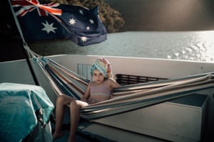 Photographer Nadia Stone’s daughter sits on a hammock with Australian flag in background