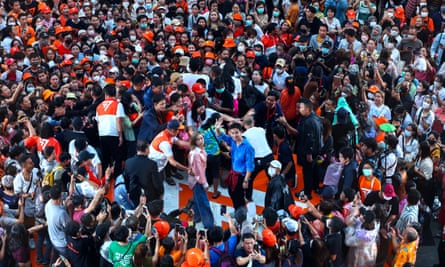 Move Forward party leader Pita Limjaroenrat waves while surrounded by crowds at a rally