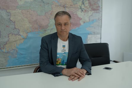 Mykola Kuleba sitting at a desk with a map of the world on the wall behind him