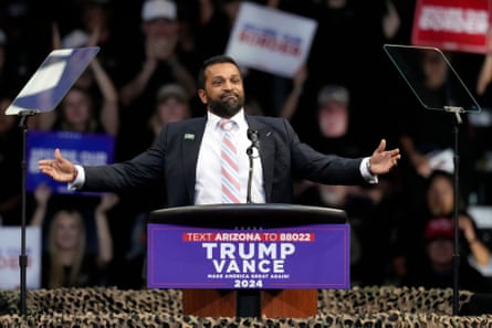 Man stands behind podium that says ‘trump-vance’, with arms spread wide