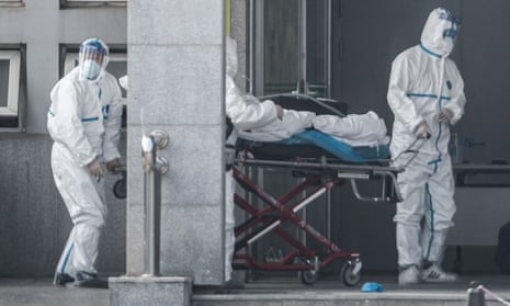 Staff carry a patient into the Jinyintan hospital, where patients infected by a mysterious Sars-like virus are being treated, in Wuhan