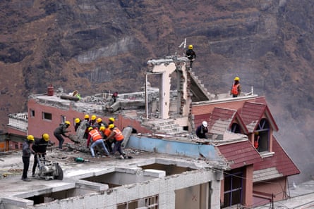 Workmen demolish a building which has developed cracks in Joshimath, in India’s Himalayan mountain state of Uttarakhand