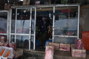 Najeeb Allah, 42, a fruit seller, stands in the doorway of his shop in Bamiyan