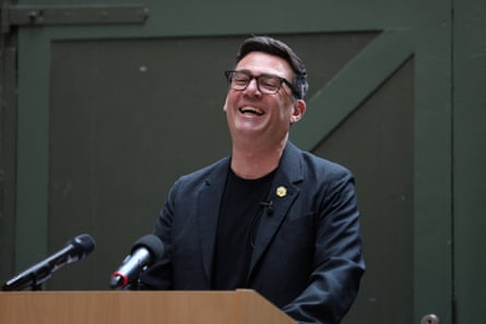 Andy Burnham laughs as he gives a speech
