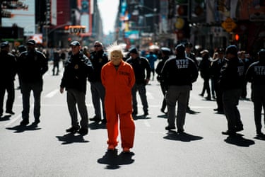 New York City, USA person in a costume depicting U.S. President Donald Trump in an orange jumpsuit passes members of the NYPD