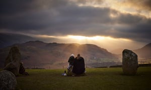 As pessoas observam o céu sombrio sobre Castlerigg em Cumbria