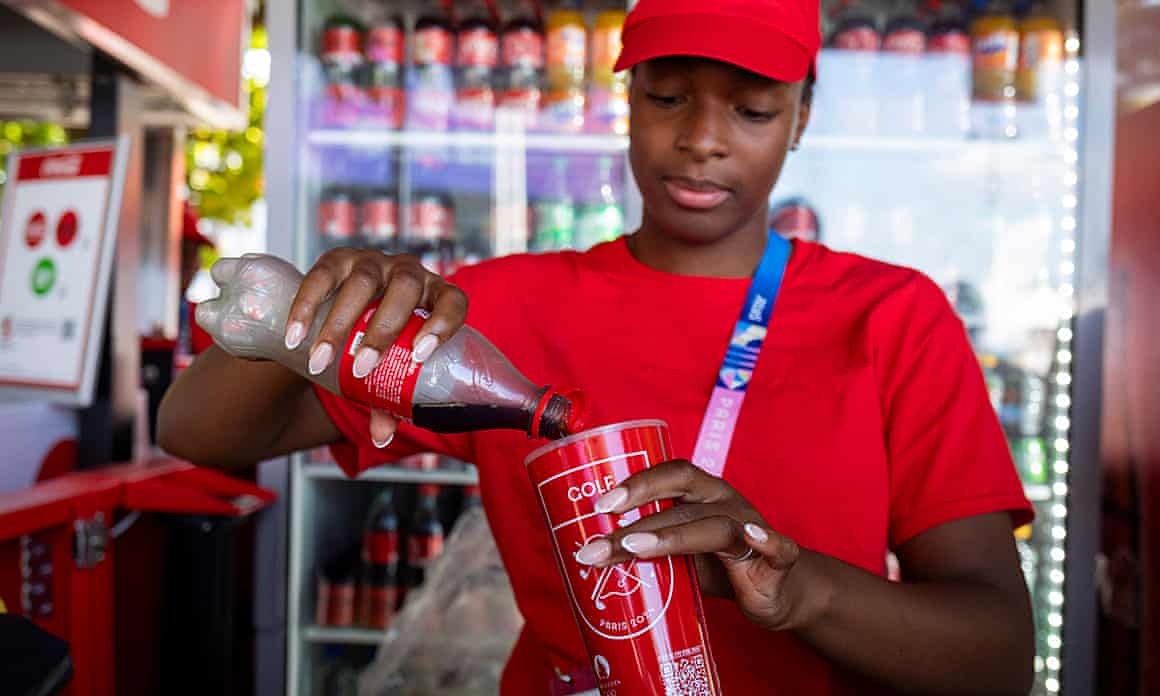 Coke being poured from a plastic bottle into a plastic cup