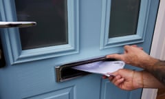 Hand putting mail through letter box in light blue door